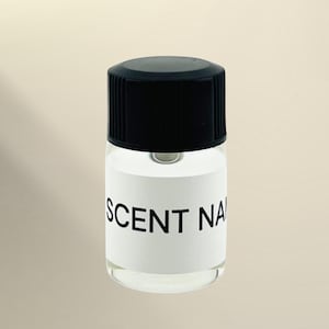 May include: A small, clear glass bottle with a black screw-top cap. The bottle features a white rectangular label wrapped around the center, printed with the black text SCENT NAME in a simple, sans-serif font. The container is empty and transparent.