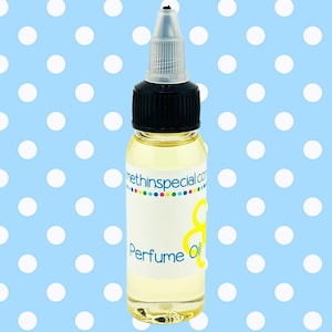 May include: A clear glass perfume oil bottle with a black cap and a white label. The label has the text "methinspecial.com" and "Perfume Oil". The background is a light blue with white polka dots.