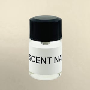 May include: A small, clear glass bottle with a black screw-top lid. The bottle features a white rectangular label wrapped around the center, printed with the black text SCENT NAME in a clean, sans-serif font. The container is transparent.