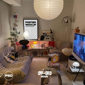 May include: A living room interior featuring a large paper globe pendant light, a low-profile beige sofa with a graphic pillow, a black framed poster mockup, a modular metal shelving unit with various decorative objects, and a metallic side table.
