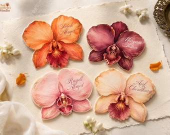Może przedstawiać: Cztery winietki w kształcie orchidei z akwarelowymi ilustracjami w kolorach pomarańczowym, ciemnoczerwonym, jasnoróżowym i brzoskwiniowym. Każda karta zawiera imię wypisane elegancką kursywą: Sarah Ahmed, Maryam Salam, Russell Ahmed i Arif Choudhury na fakturowanym papierze.