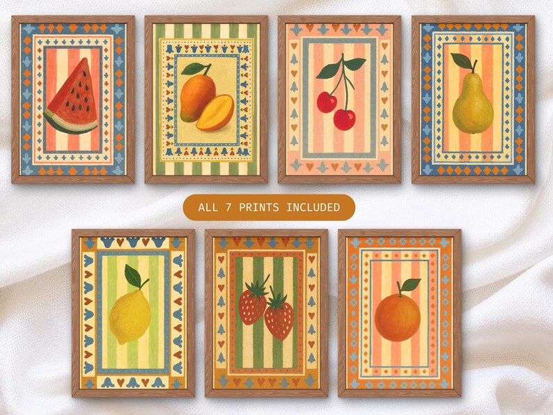 May include: Seven framed art prints featuring colorful illustrations of fruits, including a watermelon slice, mangoes, cherries, a pear, a lemon, strawberries, and an orange. Each print has a decorative border and a striped background.