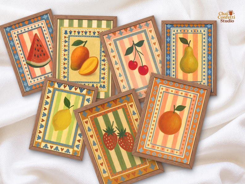 May include: A collection of framed fruit art prints. Each print features a different fruit, including a watermelon, mango, cherries, pear, lemon, strawberries, and an orange. The prints have a striped background and are framed in wood.