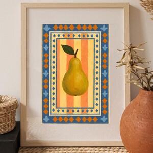 May include: A framed art print featuring a yellow pear with a green leaf, set against a striped orange and yellow background. The pear is framed by a blue and orange geometric border. The artwork is displayed in a light wood frame.