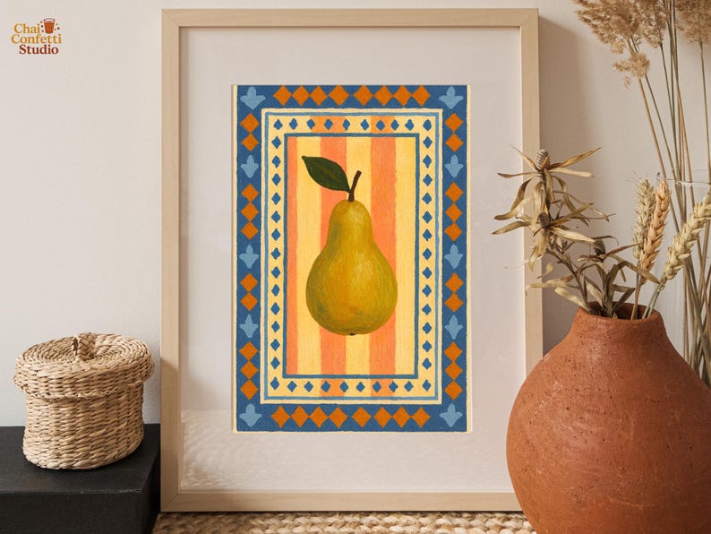 May include: A framed art print featuring a yellow pear with a green leaf, set against a striped orange and yellow background. The pear is framed by a blue and orange geometric border. The artwork is displayed in a light wood frame.
