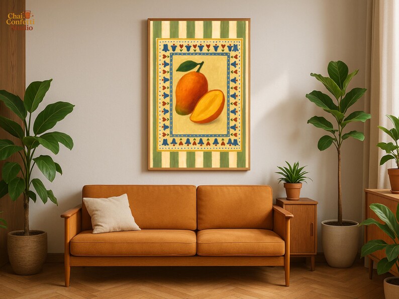 May include: A framed art print featuring a mango illustration. The artwork depicts a whole mango and a sliced mango against a yellow background with a decorative border. The frame is surrounded by a green and white striped pattern. The print hangs above an orange sofa.
