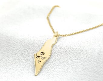 May include: A gold necklace with a pendant shaped like the outline of Israel. The pendant has Hebrew writing on it that says "Jerusalem" and "Israel".