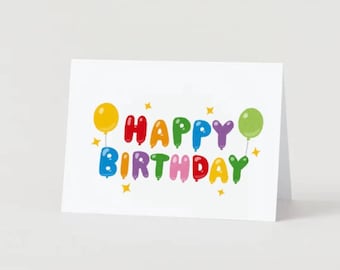Può includere: Biglietto di auguri bianco con la scritta "HAPPY BIRTHAY" in lettere colorate a forma di palloncino. Sono presenti palloncini gialli, verdi e viola, insieme a stelle gialle. Il biglietto è piegato e si regge in piedi.
