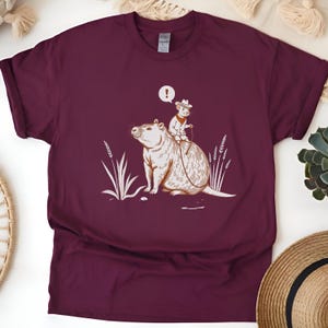 Hand-Drawn Cowboy Rat Riding Capybara shirt Western Marsh Minimalist Brown Engraved Old West Humor Animal Lover T-Shirt