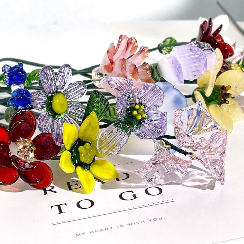 May include: A collection of multi-colored glass flowers with green wire stems, featuring red, yellow, blue, purple, and pink petals. The flowers are arranged on a white card with the printed text "READ TO GO" and "MY HEART IS WITH YOU."