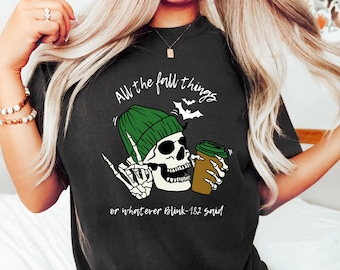 May include: Black t-shirt with a graphic of a skeleton wearing a green beanie and holding a coffee cup. The text reads "All the fall things" and "or whatever Blink-182 said."