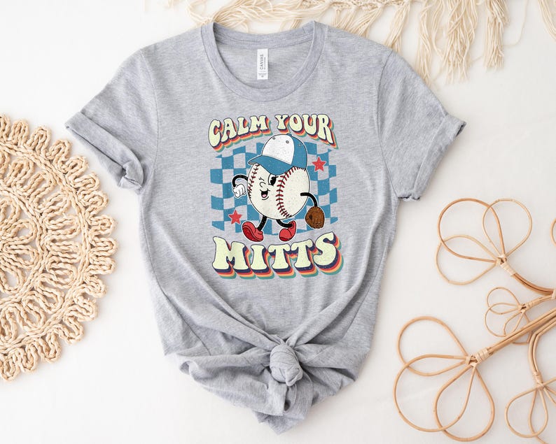 May include: Gray t-shirt with a retro baseball graphic and the text "Calm Your Mitts".