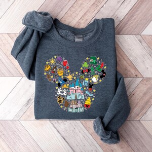 Puede incluir: Sudadera gris oscuro con un dise&ntilde;o colorido de la cabeza de Mickey Mouse. El dise&ntilde;o est&aacute; lleno de varios iconos tem&aacute;ticos de Disney, incluyendo un castillo, tazas de t&eacute; y la frase "it's a small world". La sudadera es de material suave.