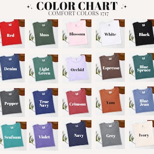 May include: A color chart featuring a variety of Comfort Colors t-shirts in various hues, including red, moss green, and blossom pink. The chart displays the color names, such as "Denim," "Crimson," and "Ivory."