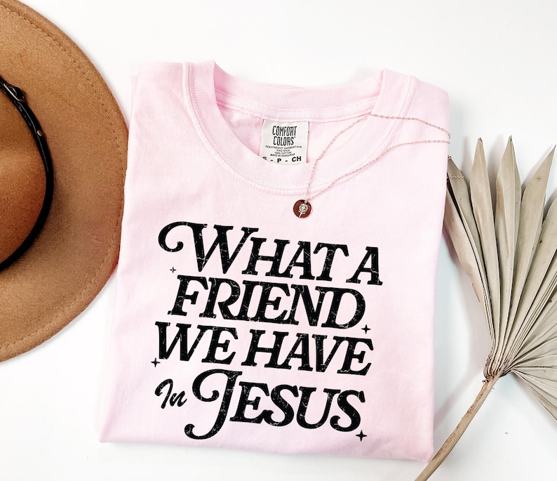 K&ouml;nnte beinhalten: Rosa T-Shirt mit schwarzem Text, der "What a Friend We Have in Jesus" lautet.