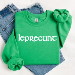 May include: A green sweatshirt with the text "leprecunt" in white lettering.