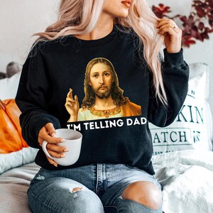 May include: Black sweatshirt with a graphic of Jesus saying "I'm telling Dad".