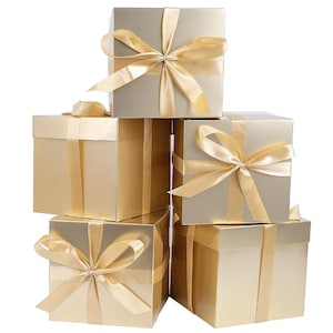 May include: A stack of five square gift boxes with a metallic gold finish. Each box is wrapped with a matching gold satin ribbon tied into a decorative bow on the front. The boxes are arranged in a pyramid formation against a plain white background.