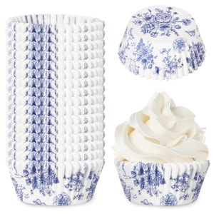 May include: A stack of white and blue floral cupcake liners. The liners have a delicate blue floral pattern and are shown with a cupcake topped with white frosting. The liners are designed for baking and decorating cupcakes.