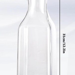 May include: A clear, rectangular-shaped pitcher with a white lid. The pitcher is 12.2 inches tall, 3.3 inches wide, and 3.1 inches across the top. The pitcher is designed for serving beverages.