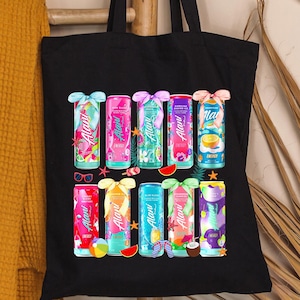 Pu&ograve; includere: Borsa tote nera con illustrazioni colorate di lattine di bevande con vari disegni. Le lattine hanno colori vivaci e temi tropicali. La borsa &egrave; appesa a una scala di legno.