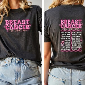May include: Dark gray t-shirt with the text "BREAST CANCER The Fight Tour" in pink. The back of the shirt also features a list of inspirational words and phrases in pink, including "Love Receiving" and "Hope Believing".