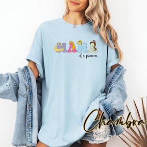 K&ouml;nnte beinhalten: Hellblaues T-Shirt mit einem Aufdruck des Wortes "Mama", das mit Disney-Prinzessinnen-Charakteren ausgeschrieben ist. Der Text "of a princess" befindet sich unter dem Aufdruck.