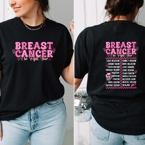 May include: Black t-shirt with the text "BREAST CANCER The Fight Tour" in pink, with butterfly accents. The back of the shirt features a list of inspirational words and phrases in pink.