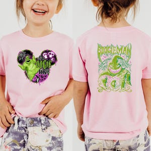May include: Pink short-sleeved t-shirt featuring a graphic of a green character with the text "Let's Oogie Boogie" on the front. The back of the shirt displays a green graphic of the same character with the text "Boogie Man".