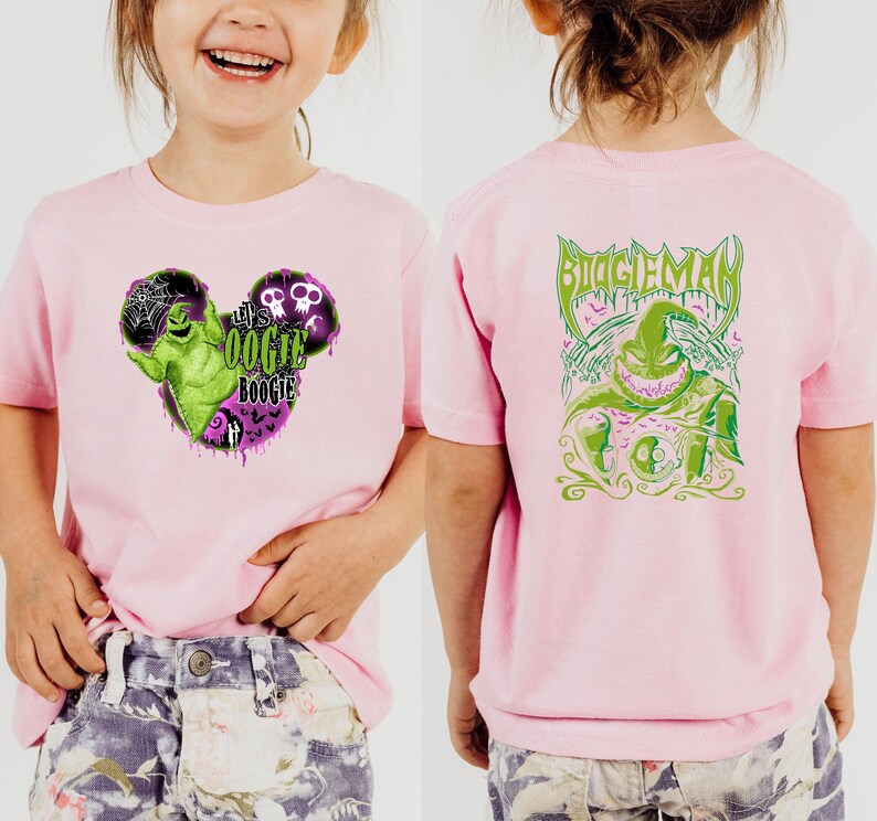 May include: Pink short-sleeved t-shirt featuring a graphic of a green character with the text "Let's Oogie Boogie" on the front. The back of the shirt displays a green graphic of the same character with the text "Boogie Man".