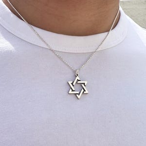 May include: A silver chain necklace with a silver Star of David pendant.