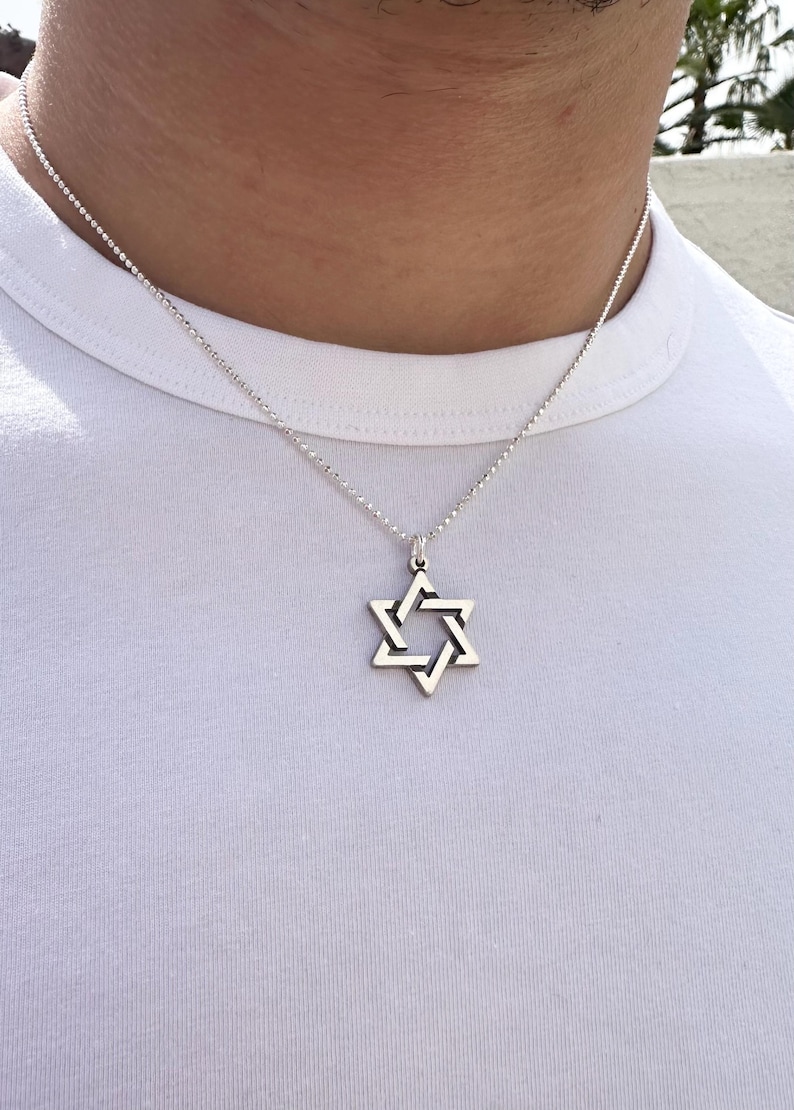May include: A silver chain necklace with a silver Star of David pendant.