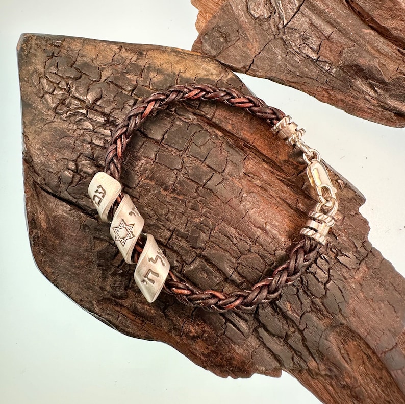 May include: A brown leather bracelet with silver beads. The beads are engraved with Hebrew letters and a Star of David.