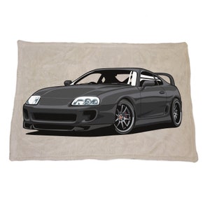 May include: A black Toyota Supra sports car with a white background. The car has a black interior and black wheels with red accents.