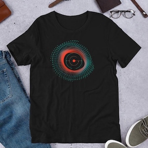 a black t-shirt with a graphic design of a circular pattern in red and green colors, along with a pair of jeans and a pair of sneakers.