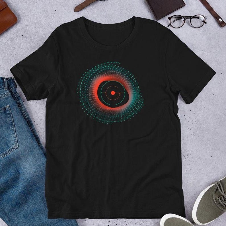 a black t-shirt with a graphic design of a circular pattern in red and green colors, along with a pair of jeans and a pair of sneakers.
