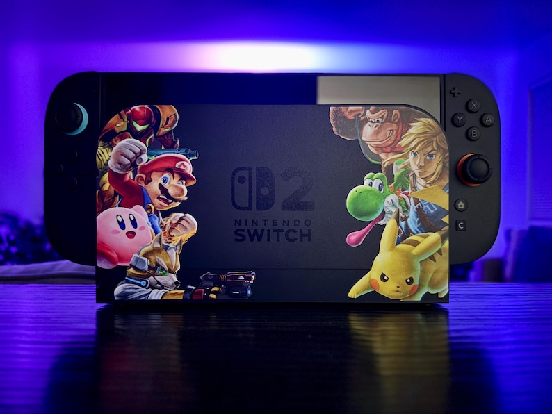 May include: A black Nintendo Switch console with a custom skin featuring characters like Mario, Kirby, and Pikachu. The console is on a dark surface, with a purple and blue gradient background. The Nintendo Switch logo is visible.