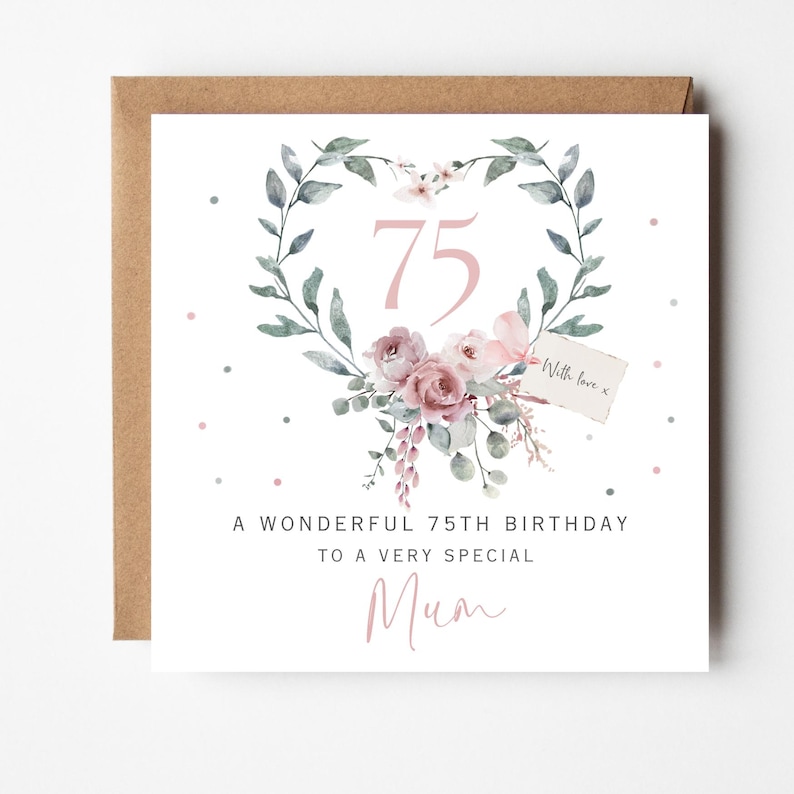 May include: A square greeting card with a kraft envelope featuring a heart-shaped wreath of green leaves and dusty pink roses. The number 75 is centered in pink. Text reads: A WONDERFUL 75TH BIRTHDAY TO A VERY SPECIAL Mum, with a small tag saying With love x.