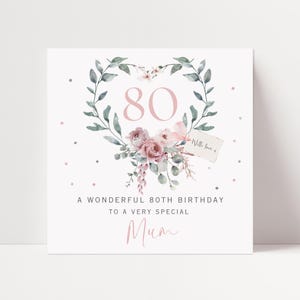 May include: A square greeting card featuring a watercolor heart-shaped wreath of green leaves and dusty pink roses surrounding the number 80. The text reads A WONDERFUL 80TH BIRTHDAY TO A VERY SPECIAL Mum with a small tag saying With love x.
