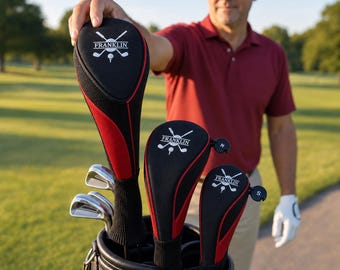 Puede incluir: Un juego de tres fundas para palos de golf en negro y rojo con el logotipo de Franklin y un gráfico de palos cruzados. Las fundas presentan un diseño de tela texturizada, cuellos de punto negro y etiquetas circulares marcadas M y S.