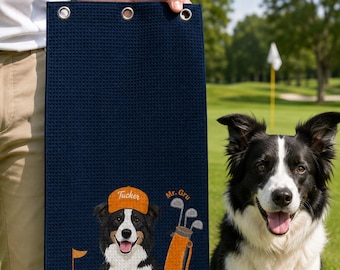 Puede incluir: Una toalla de golf azul marino con textura de gofre que presenta un gráfico bordado de un border collie blanco y negro con una gorra naranja etiquetada como Tucker, una bolsa de golf naranja con palos y una bandera, con el texto Mr. Gru bordado.