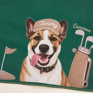 Puede incluir: Una toalla de color verde oscuro con textura de gofre que muestra un perro marr&oacute;n y blanco con una gorra beige con el nombre Tommy impreso. A la derecha, una bolsa de golf con el nombre Cameron impreso encima y una bandera de golf a la izquierda.