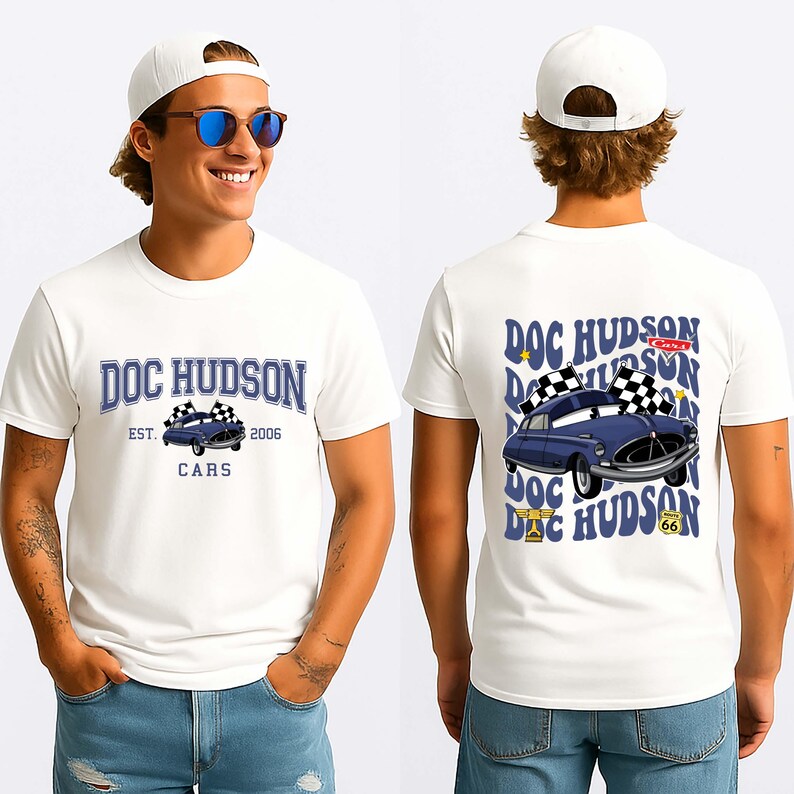 May include: White t-shirt with a blue cartoon car graphic and the text "DOC HUDSON" and "CARS" on the front. The back of the shirt repeats the graphic and text. The shirt also has the text "EST. 2006".