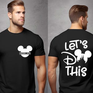 May include: Black t-shirt with a white Mickey Mouse design on the front and back. The front features a Mickey Mouse head with space for a custom name. The back says "Let's Do This" with a Mickey Mouse head and castle silhouette.