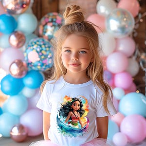 Peut inclure: Une jeune fille portant un t-shirt blanc avec un motif aquarelle color&eacute; de Moana du film Disney Moana. Le motif repr&eacute;sente Moana debout dans une vague avec un fond de coucher de soleil.
