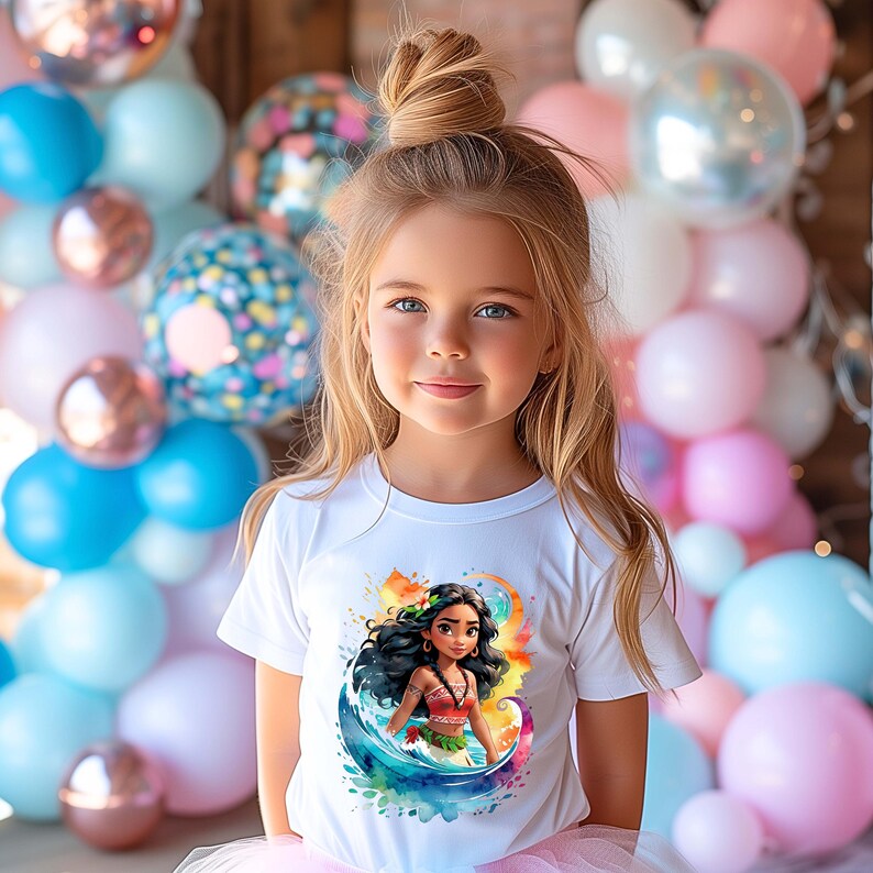 Peut inclure: Une jeune fille portant un t-shirt blanc avec un motif aquarelle color&eacute; de Moana du film Disney Moana. Le motif repr&eacute;sente Moana debout dans une vague avec un fond de coucher de soleil.