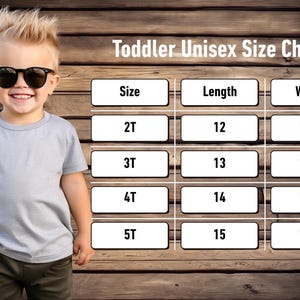 May include: A young child wearing sunglasses and a grey t-shirt stands in front of a wooden background. The image includes a "Toddler Unisex Size Chart" with size, length (inches) and width (inches) measurements for sizes 2T to 5T.