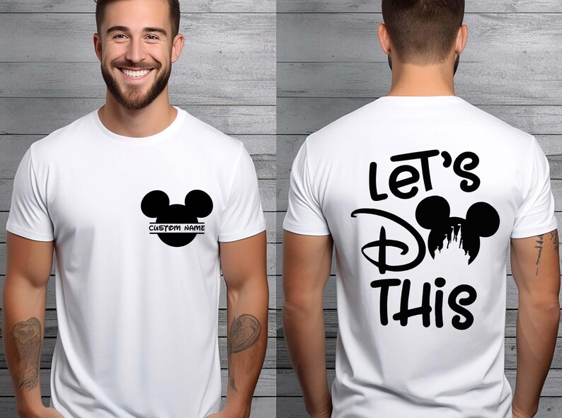 May include: White t-shirt featuring a black Mickey Mouse head design. The front has a customizable name area, and the back displays the text "Let's Do This" with a Mickey Mouse silhouette. A casual, everyday wear tee.