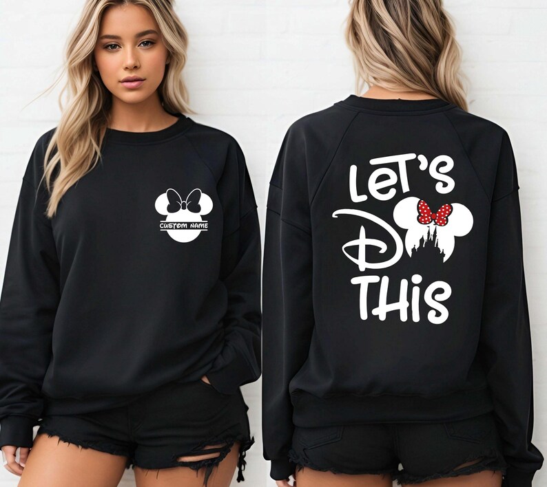 May include: Black sweatshirt with white Minnie Mouse graphic on the front and back. The front graphic includes a bow and space for a custom name. The back features the text "Let's Do This" with a Minnie Mouse design.