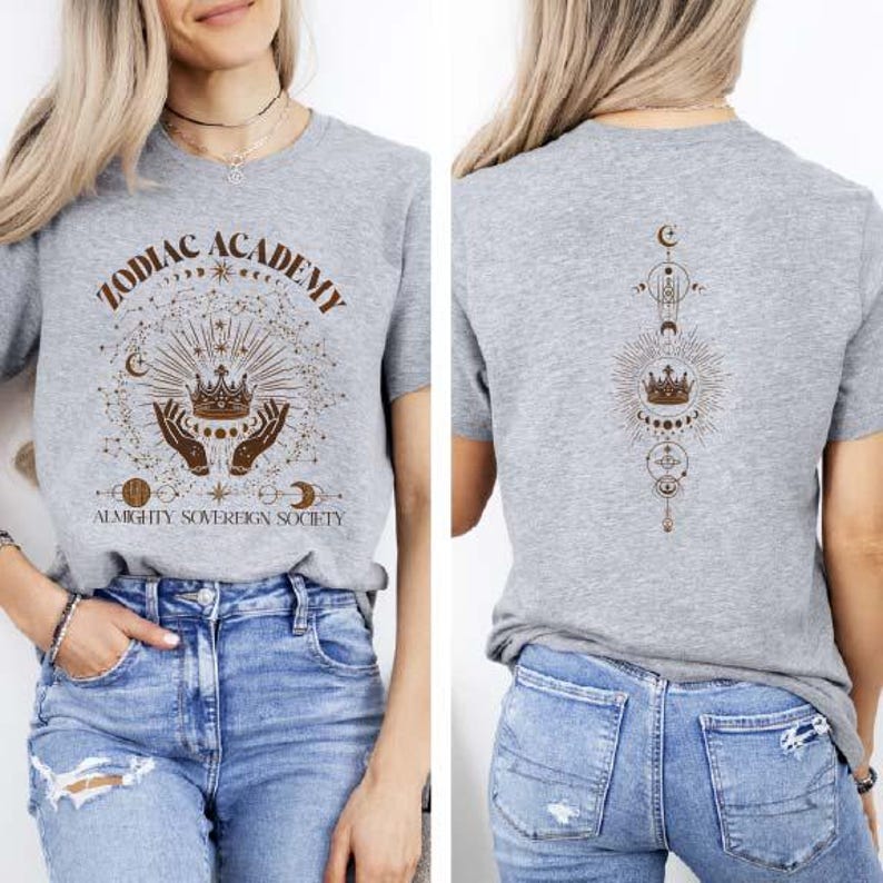 May include: Gray t-shirt with a graphic print of a crown, hands, and celestial symbols. The text "Zodiac Academy Almighty Sovereign Society" is printed on the front of the shirt.